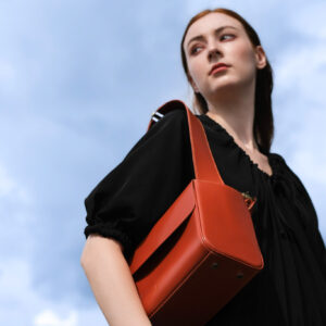 Bartin's Bozo23 premium leather bag held as handbag by woman in black dress.