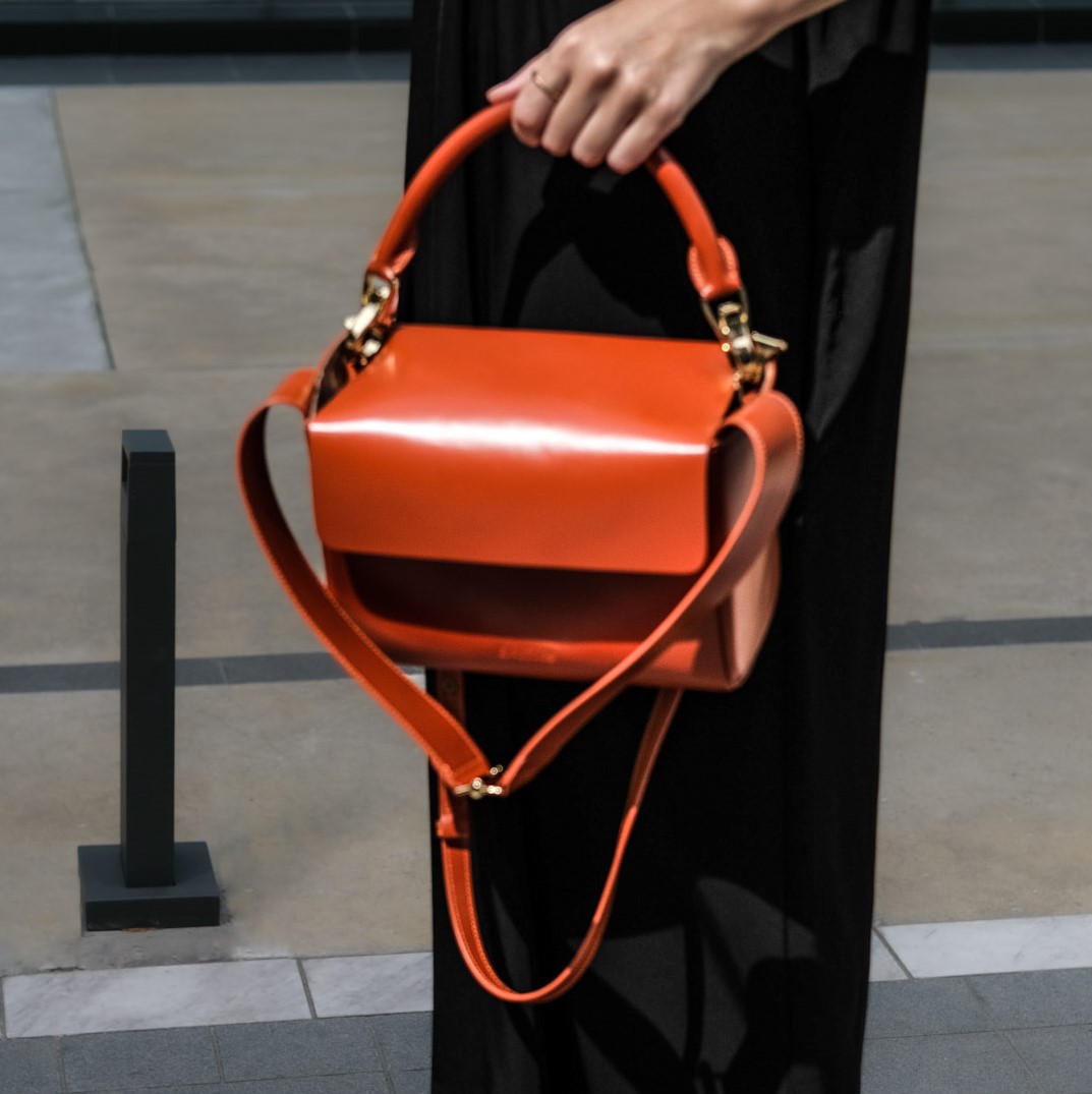 leather handbag being held showing off straps