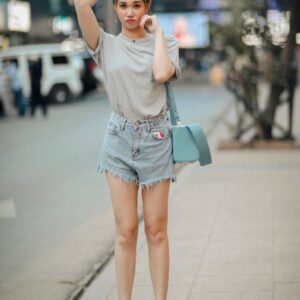 Nonnie holding blue leather handbag standing in siam bangkok